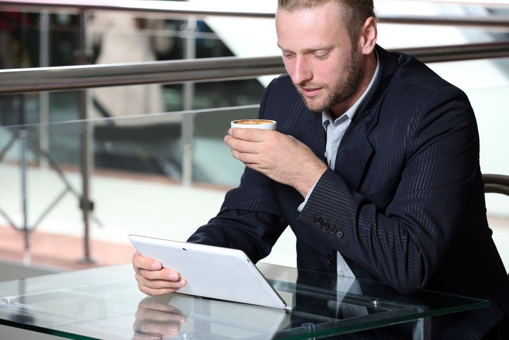businessman-having-coffee-looking-tablet