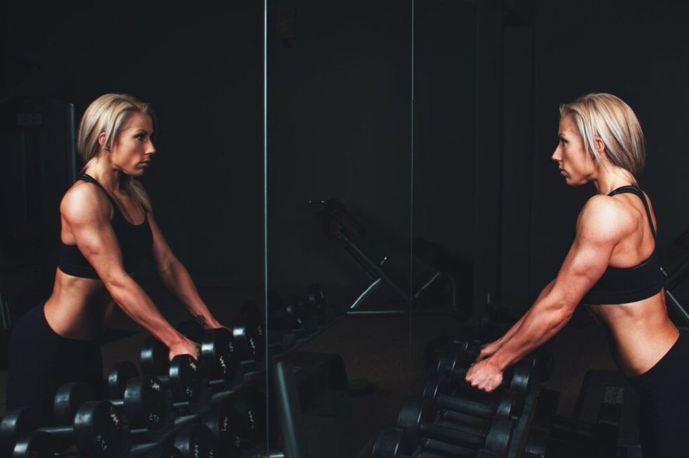 woman-lifting-weights-looking-mirror