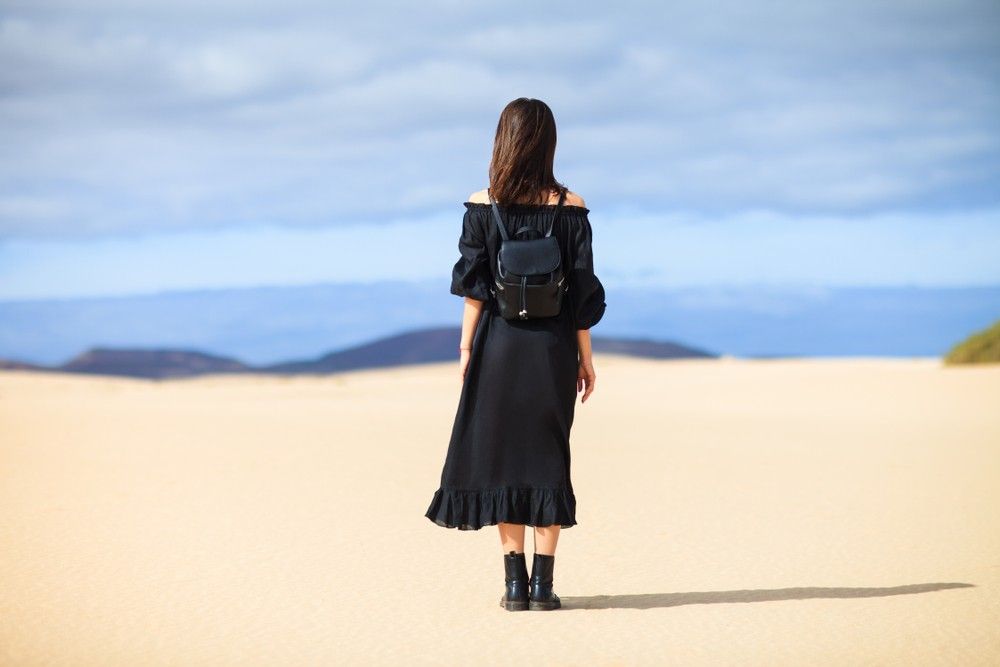 woman-black-dress-looking-desert