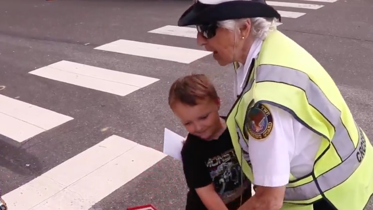 A crossing guard hugs a child