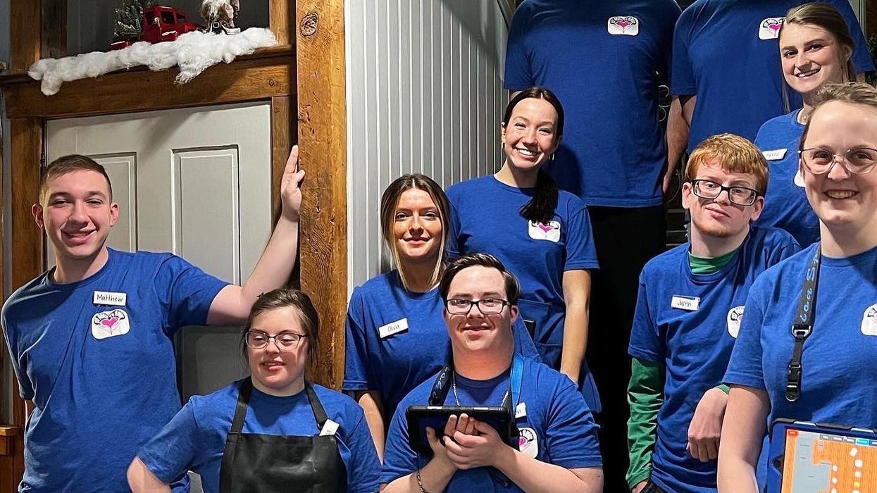A group of people, all wearing blue t-shirts and aprons.