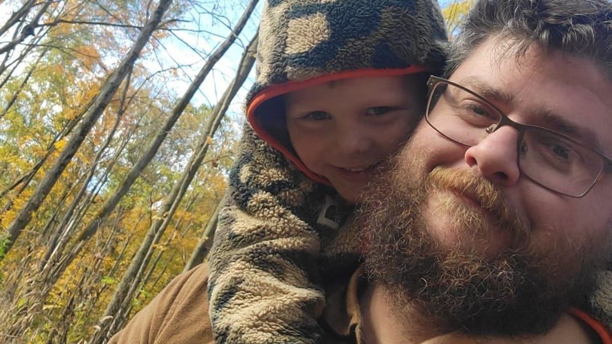 A man and a little boy in the forest.