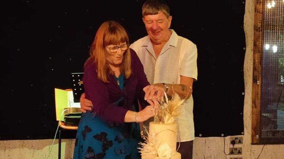 a man and woman cutting a cake
