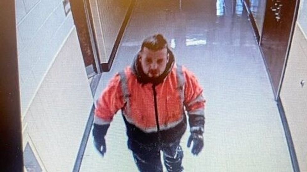 a man wearing an orange and black jacket