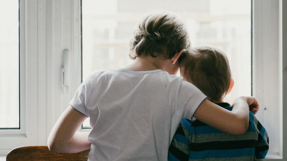 a person in white clothes hugging a person in blue and black striped shirt