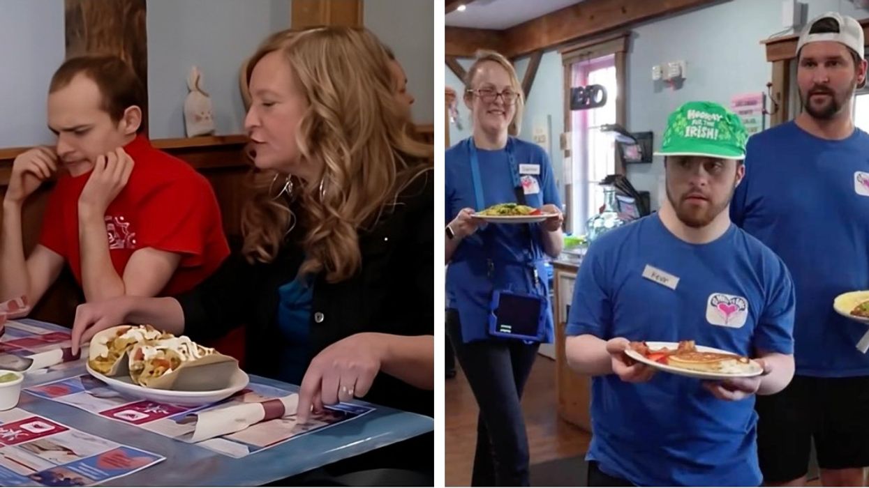 A woman eating with her son and a three cafe employees holding plates of food.
