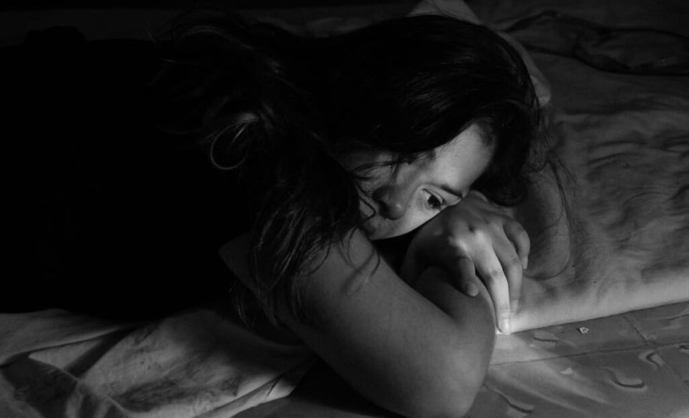 abused girlfriend lies on a bed