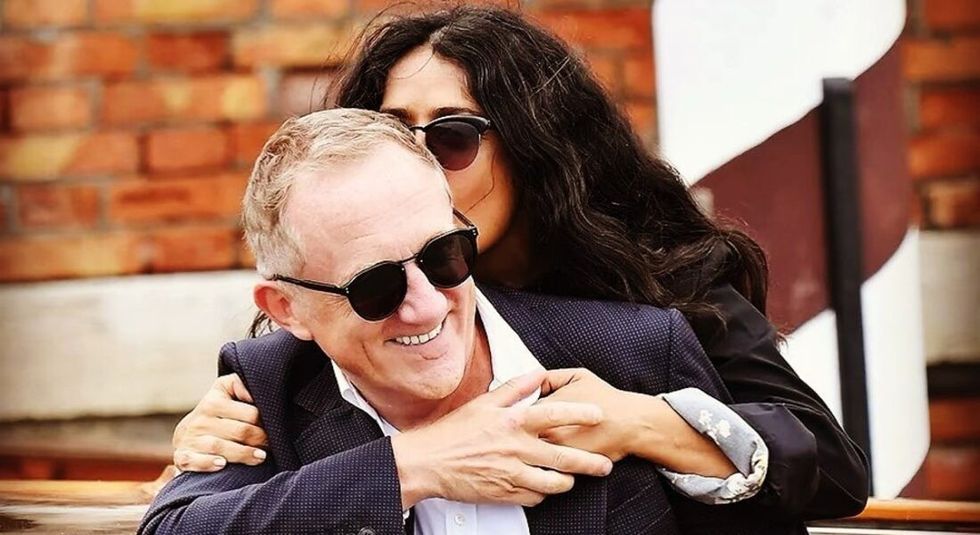 Actress Salma Hayek kissing husband Francois-Henri Pinault while they both laugh.