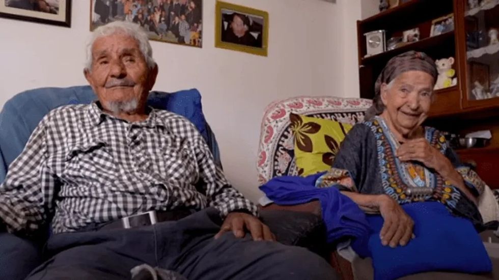 an elderly man and elderly woman sitting in two chairs