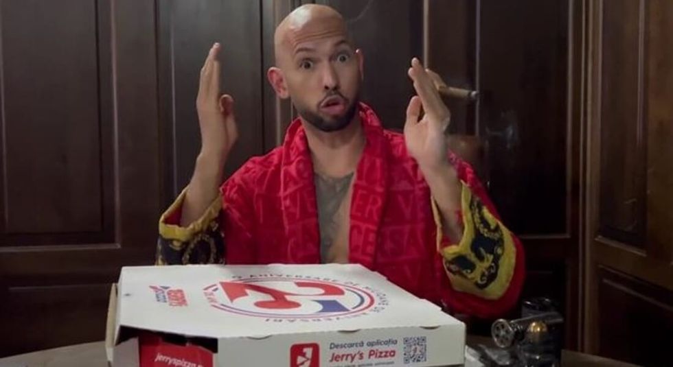 Andrew Tate with a cigar and pizza boxes.
