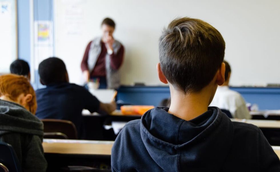 back of young students head in classroom