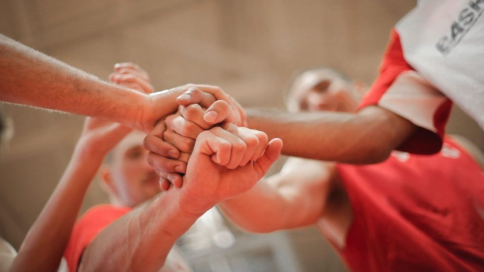 basketball team stacking hands