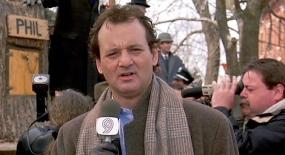 Bill Murray on the set of Groundhog Day talking into a microphone.