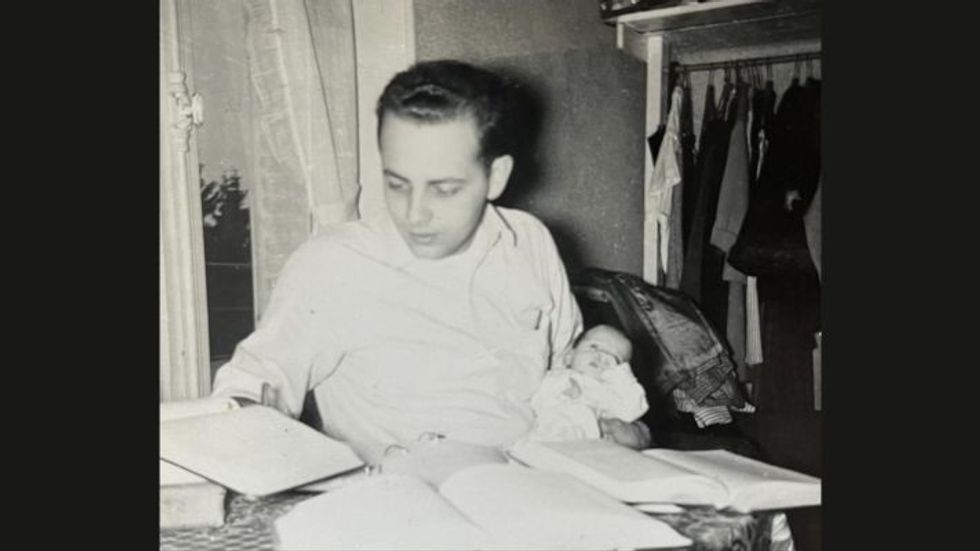 black and white photo of a young man holding a baby