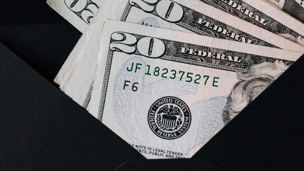 black envelope filled with money