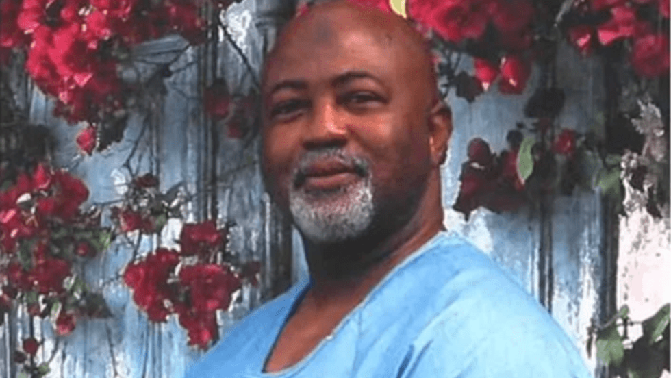 black man standing in front of flowers