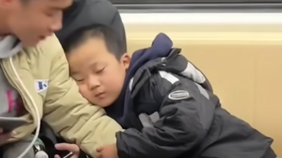 boy sleeping on a university student's arm