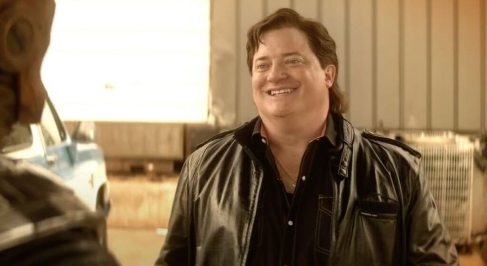 Brendan Fraser in The Whale wearing black leather jacket and smiling.