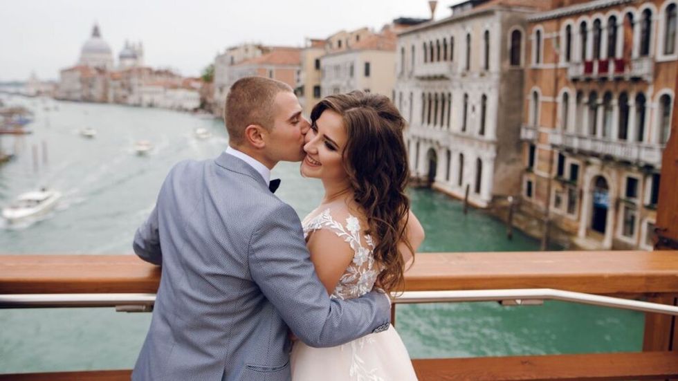 bride and groom standing on bridge