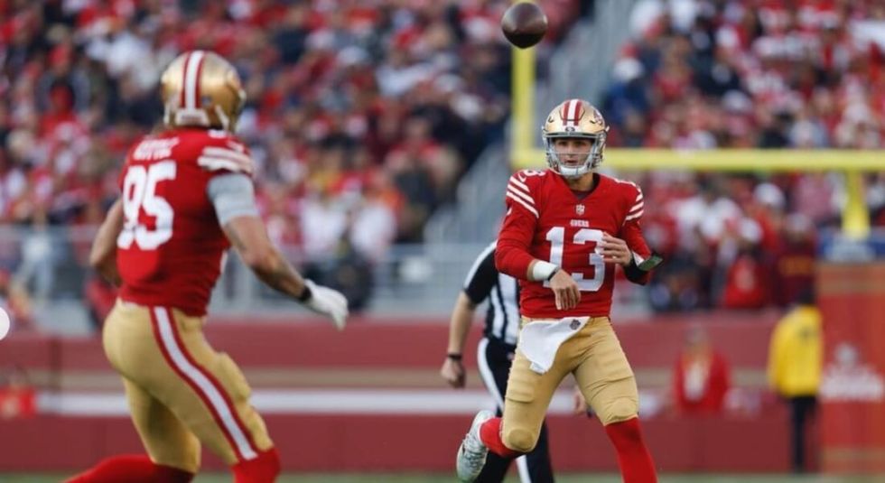 Brock Purdy throwing the football to team mate.