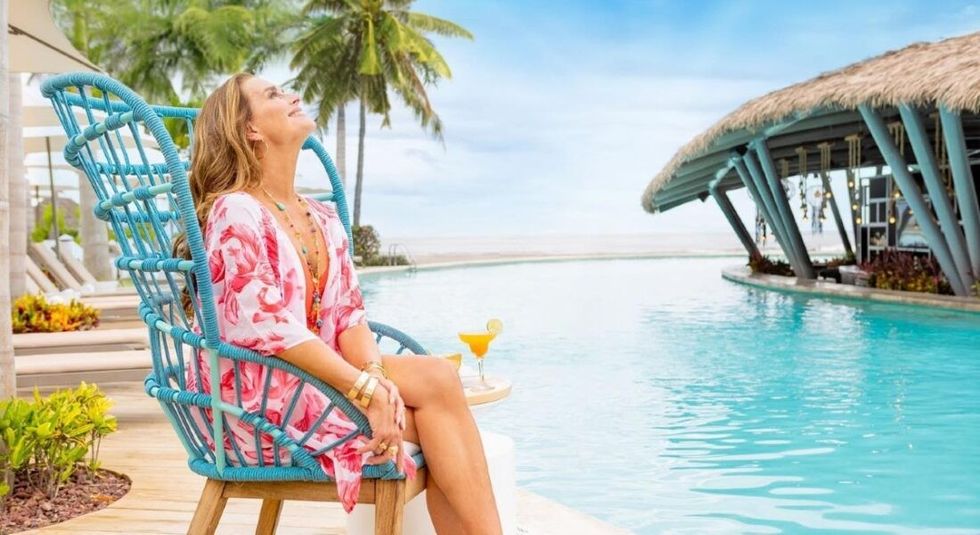Brooke Shields happy and smiling by a pool.