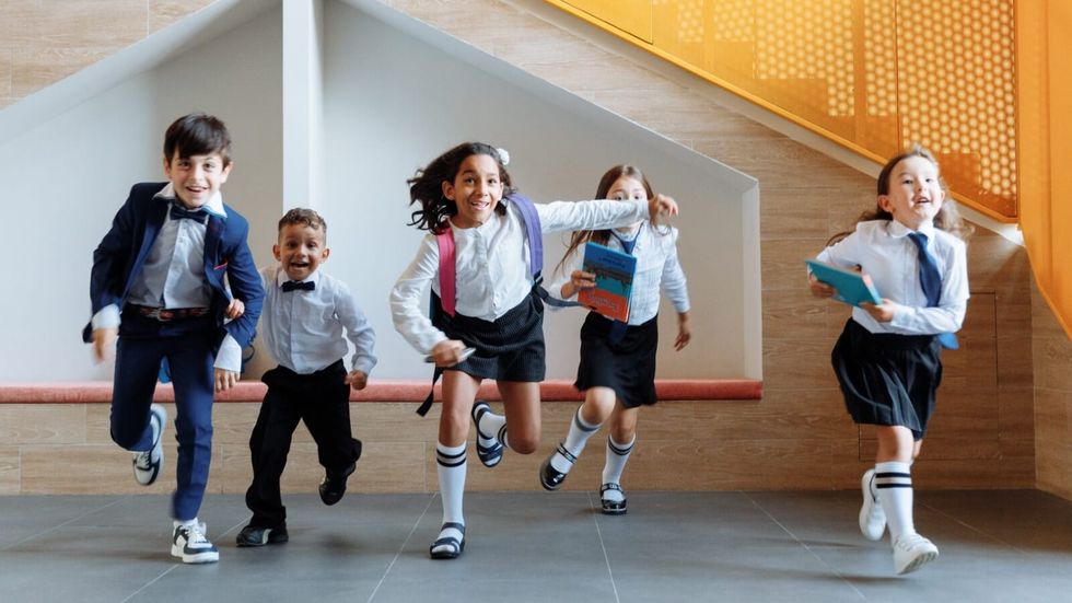 children in school uniforms running