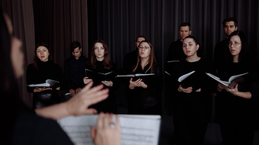 choir singing while holding sheets