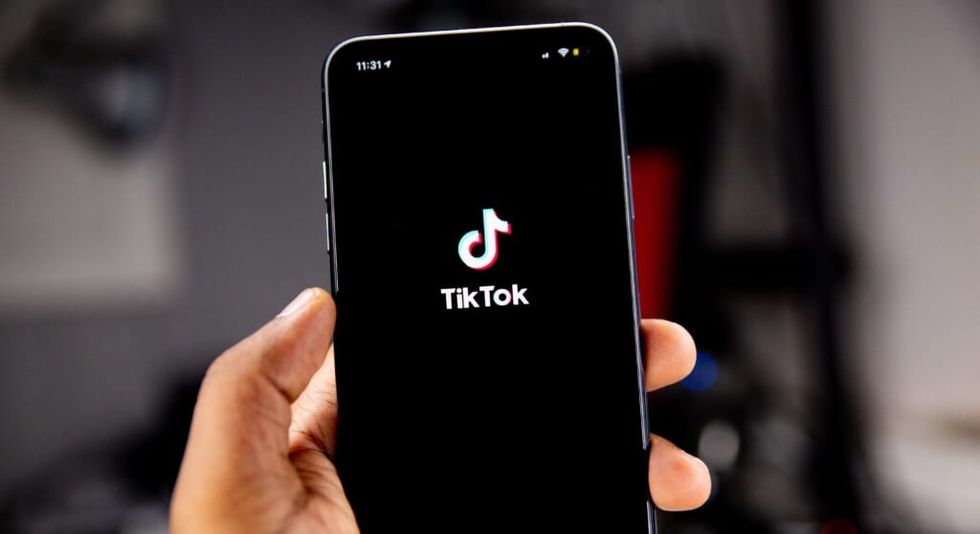 close up of tiktok app opening hand visible