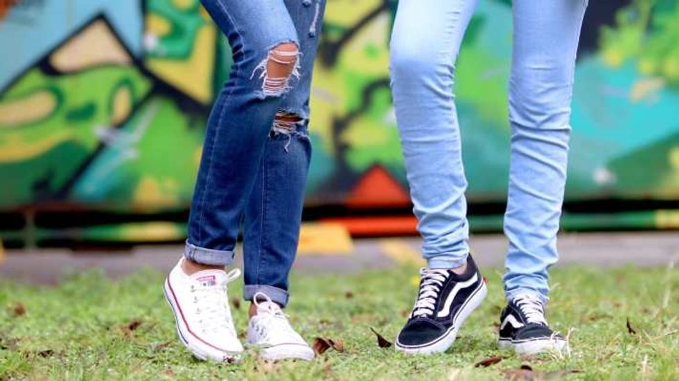 close up of two people's legs and shoes