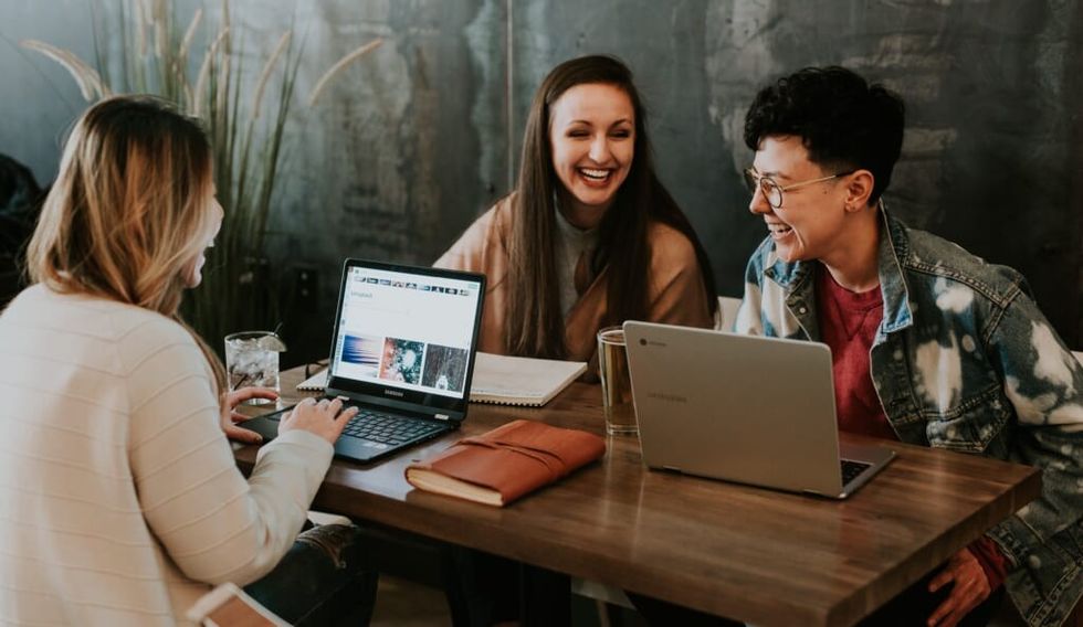 colleagues sit at table laughing