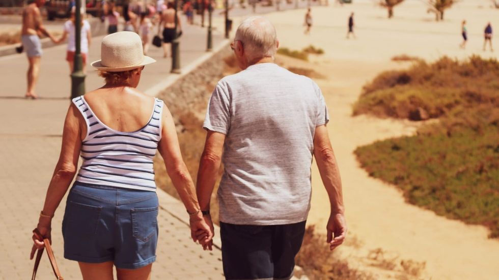 couple holding hands and walking on a beach