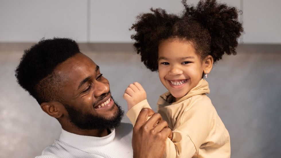 dad carrying a smiling daughter