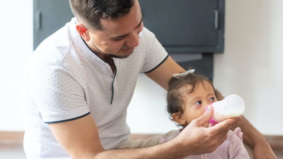 dad feeding daughter with a bottle
