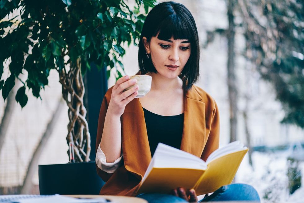 dark-haired-woman-drinking-coffee-while-reading-smart-book