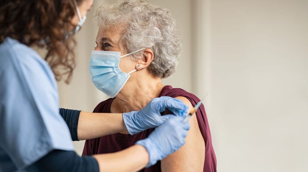 Doctor giving Covid vaccine to senior woman