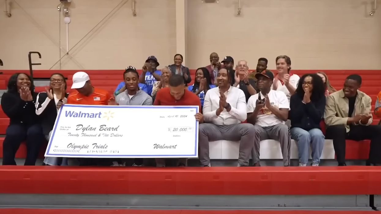 Dylan Beard holds up $20,000 Walmart Cheque Beside Friends and Family.
