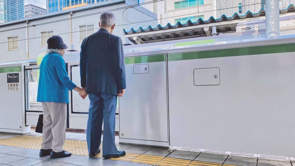 elderly couple holding hands