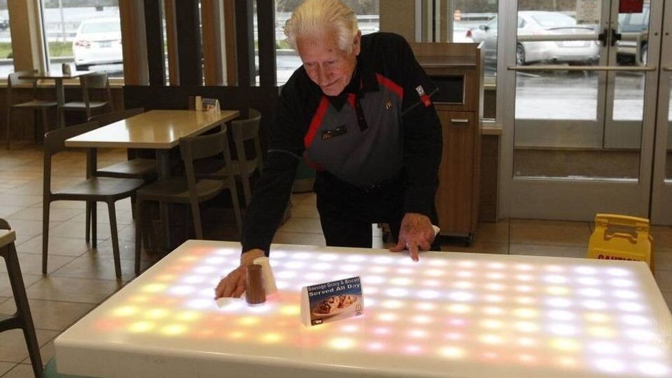 elderly man cleaning a table
