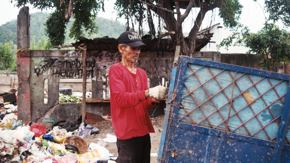elderly man wearing a red long sleeve shirt working