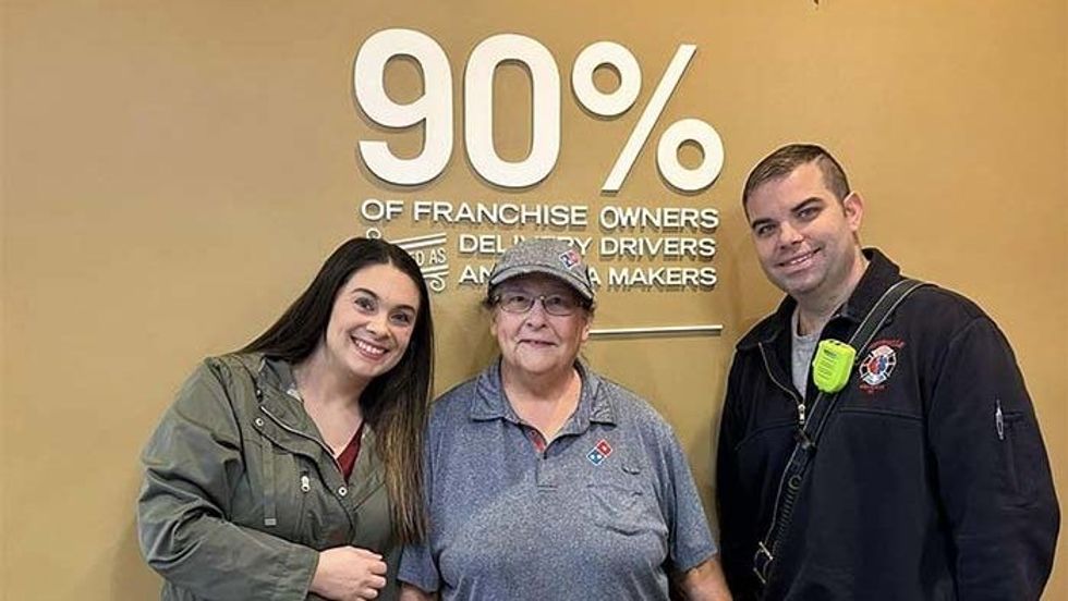 elderly woman standing with a man and a woman