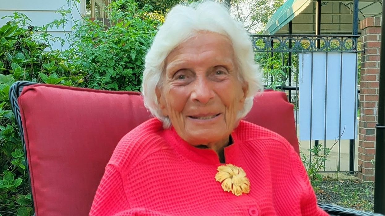 Elderly woman wearing a pink sweater.