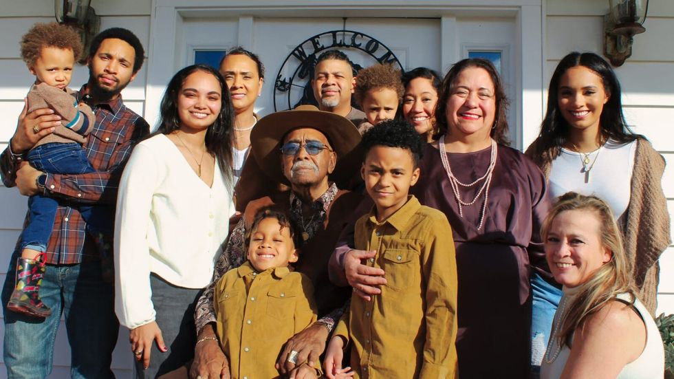 family standing in front of a white wall