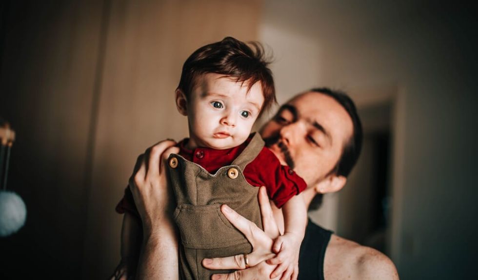 father and son pose inside their home