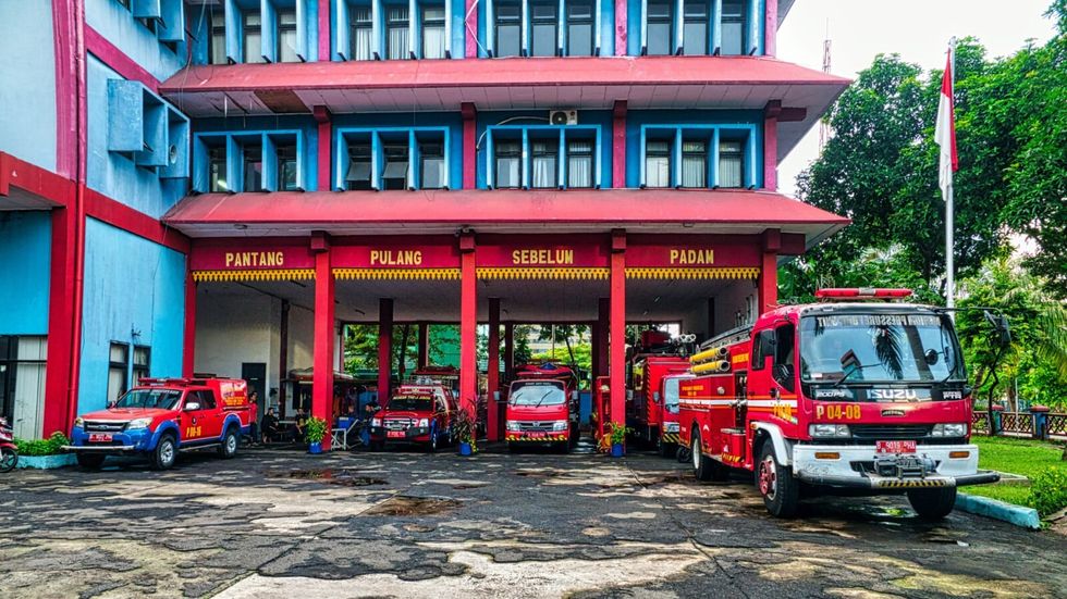 fire trucks parked outside red and blue building
