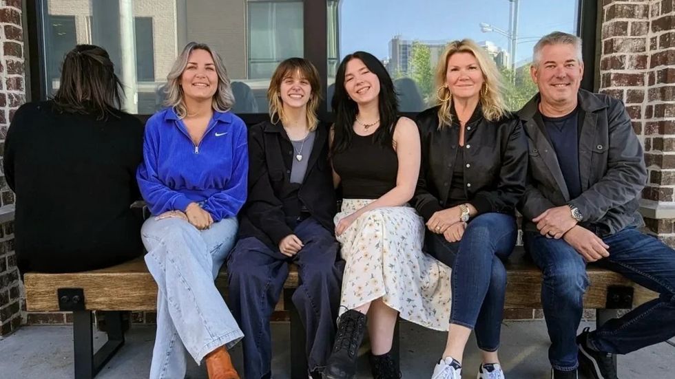 five people sitting on a bench