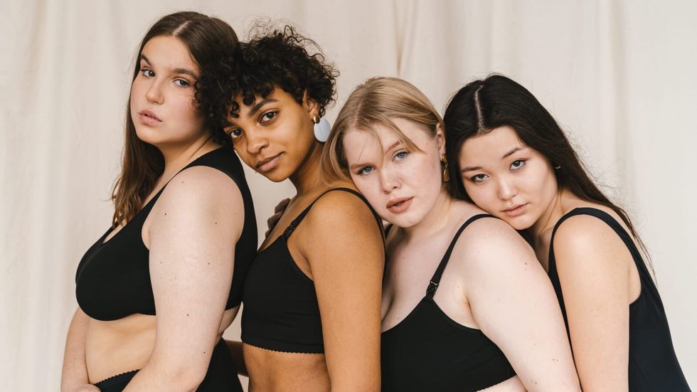 four women standing behind one another in black clothes