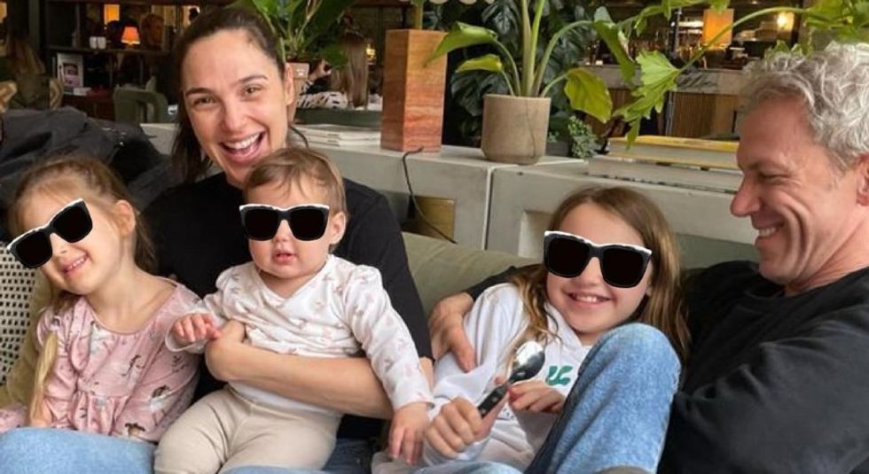 Gal Gadot and husband Jaron Versano posing with their three children on a couch.