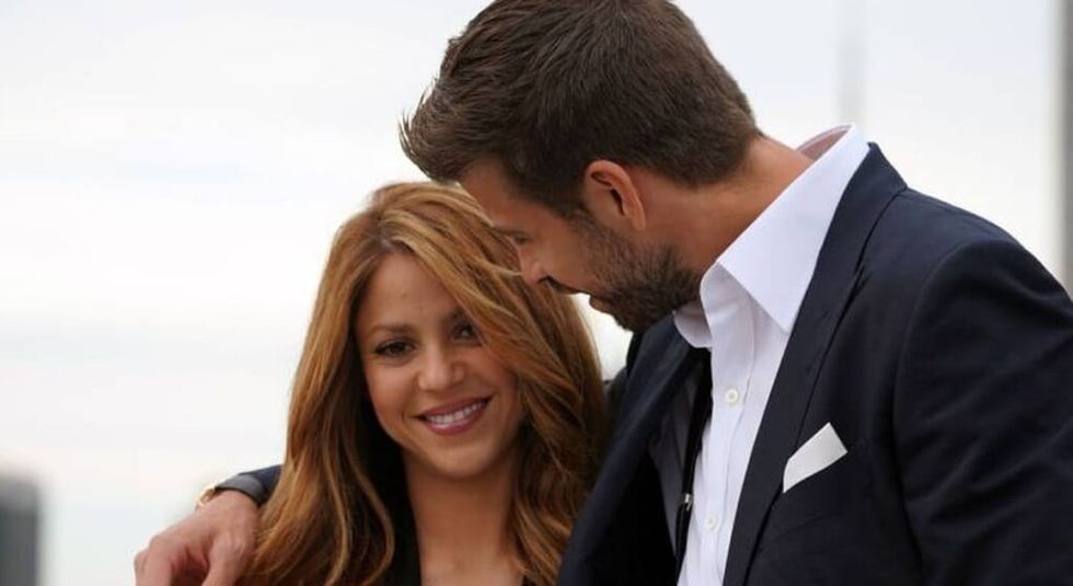 Gerard Pique hugging singer Shakira who is smiling.