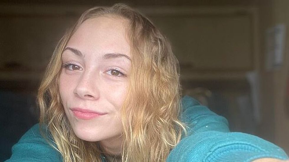 girl with blond hair wearing a blue sweatshirt