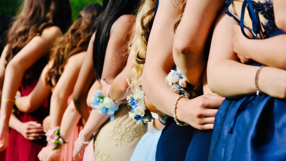 girls wearing formal gowns getting ready for prom